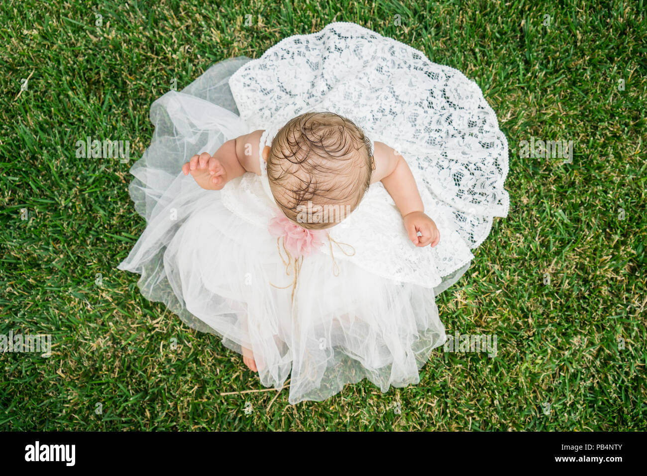Beautiful little girl wearing white dress sitting on the grass Stock ...