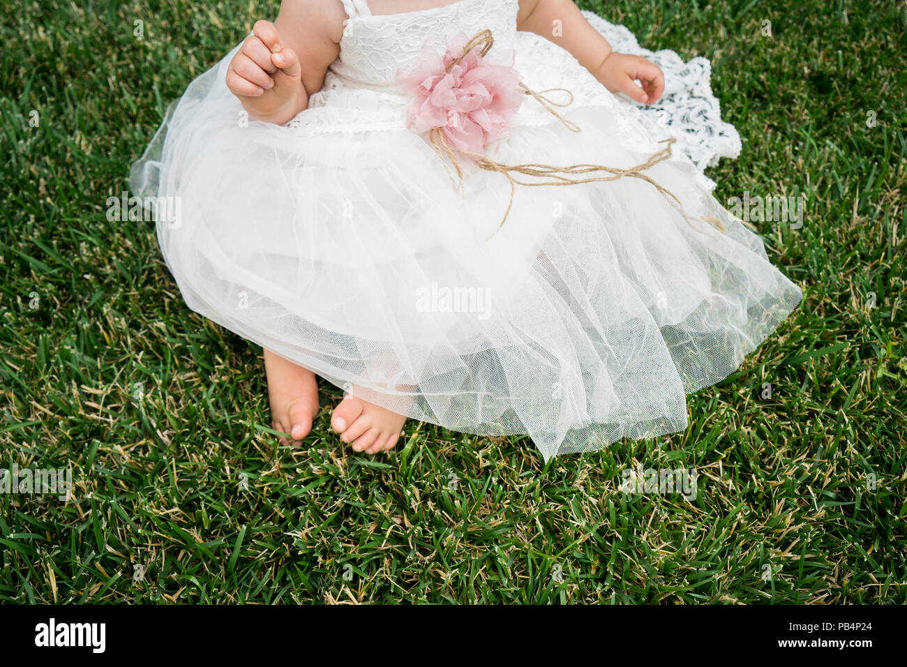 Beautiful little girl wearing white dress sitting on the grass Stock ...