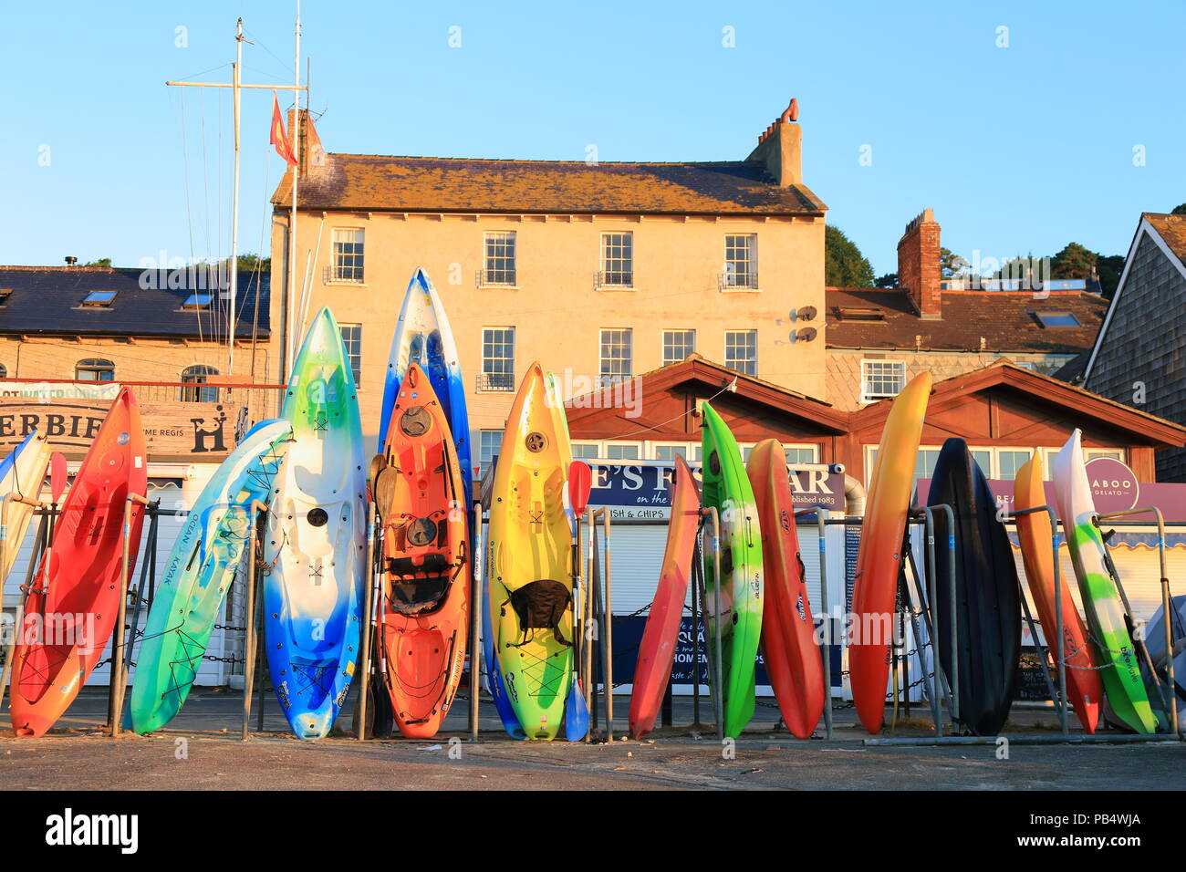 Row of colourful kayaks in Lyme Regis, Dorset Stock Photo