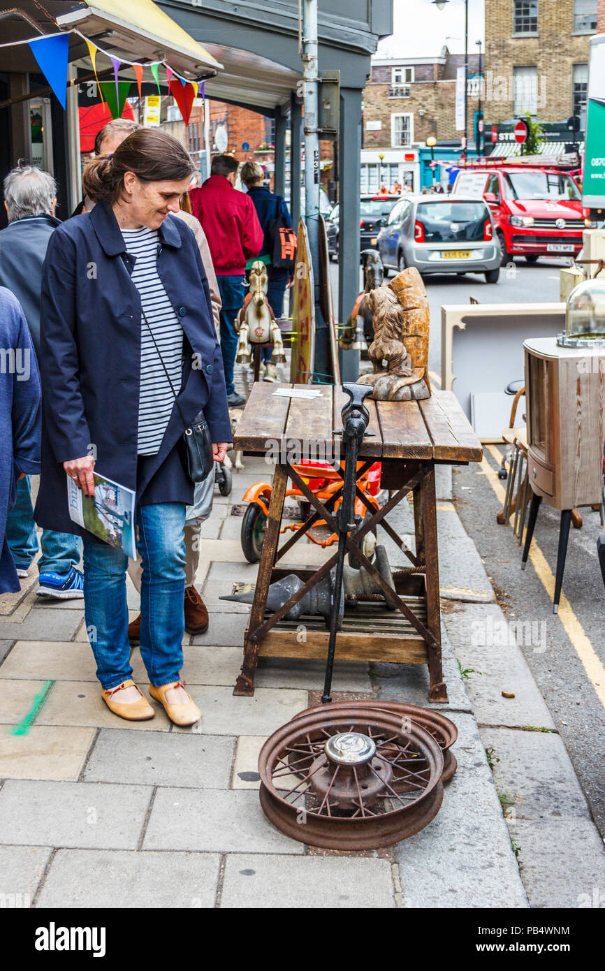 Passersby stop to look at retro bric-a-brac outside a shop in Highgate Village, London, UK Stock Photo