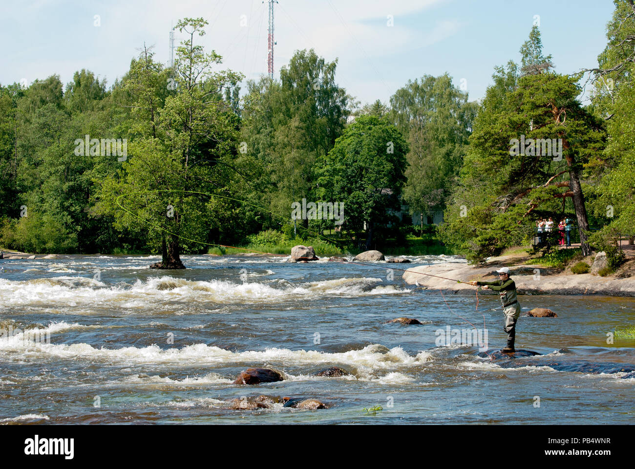 KOTKA, FINLAND - JUNE 26, 2016: Fisherman near Langinkoski Rapid on Kymi River next to The Russian Emperor Alexander III fishing lodge. Stock Photo