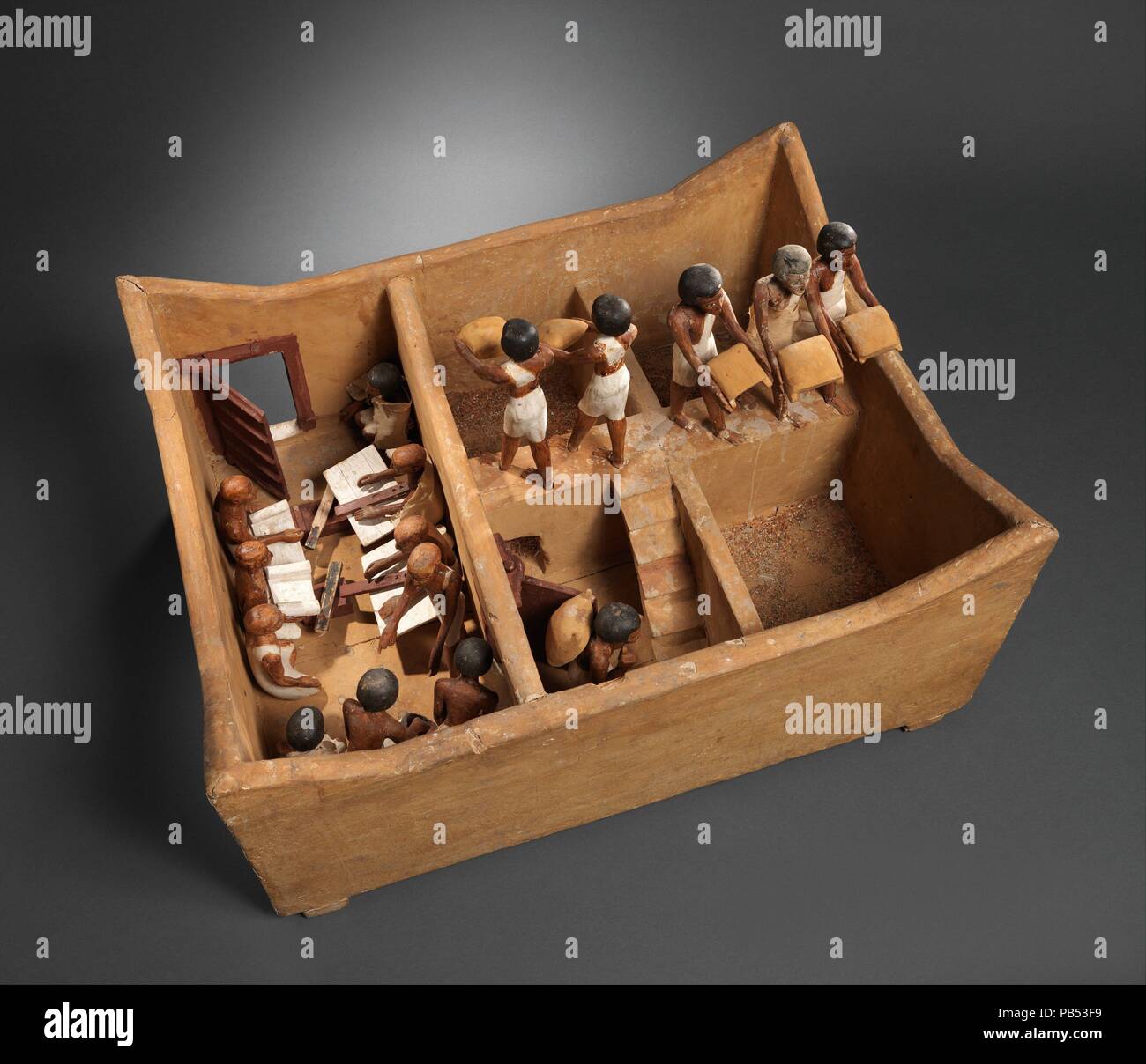 Model of a Granary with Scribes. Dimensions: L. 74.9 (29 1/2 in); W. 56 cm (22 1/16 in); H. 36.5 (14 3/8 in);  average height of figures: 20 cm (7 7/8 in.). Dynasty: Dynasty 12. Reign: early reign of Amenemhat I. Date: ca. 1981-1975 B.C..  This model of a granary was discovered in a hidden chamber at the side of the passage leading into the rock cut tomb of the royal chief steward Meketre, who began his career under King Nebhepetre Mentuhotep II of Dynasty 11 and continued to serve successive kings into the early years of Dynasty 12.  The four corners of this model granary are peaked in a mann Stock Photo