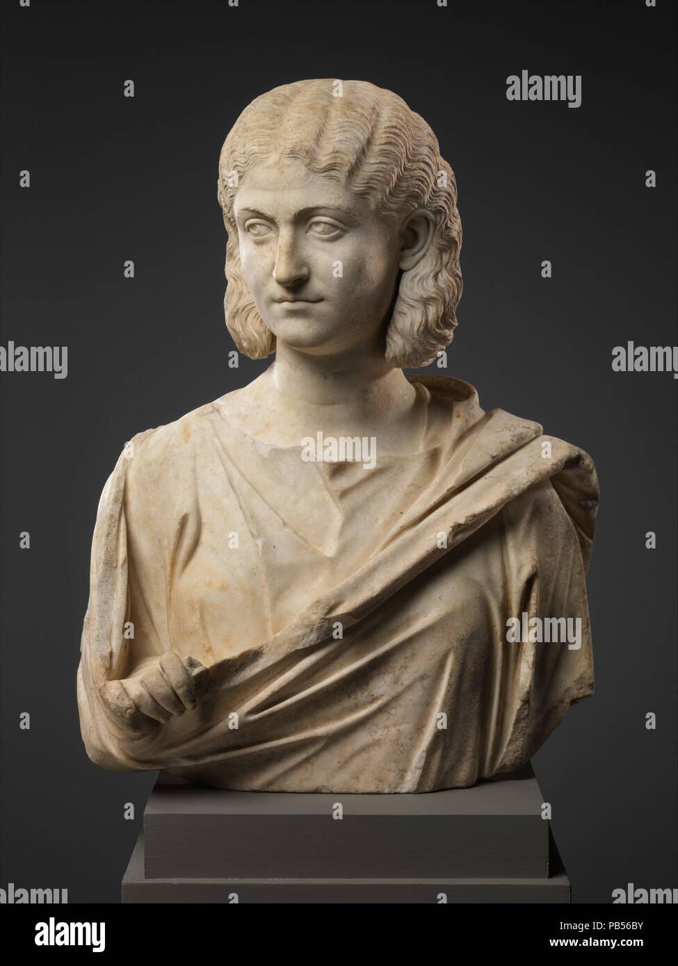 Marble bust of a woman. Culture: Roman. Dimensions: H. 25 5/8 in. (65.1 cm). Date: mid-3rd century A.D..  The subject of this extremely fine portrait wears her hair in a fashion associated with Otacilia Severa, wife of the emperor Philip the Arab (r. A.D. 244-249). The wavy hair is parted in the center, looped back over the ears to form a wide flat braid pinned to the back of the head. Museum: Metropolitan Museum of Art, New York, USA. Stock Photo