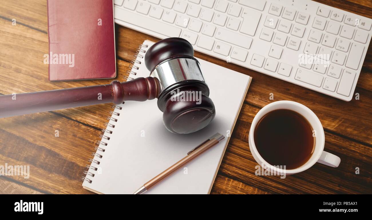 Gavel and keyboard with notepads and coffee on desk Stock Photo