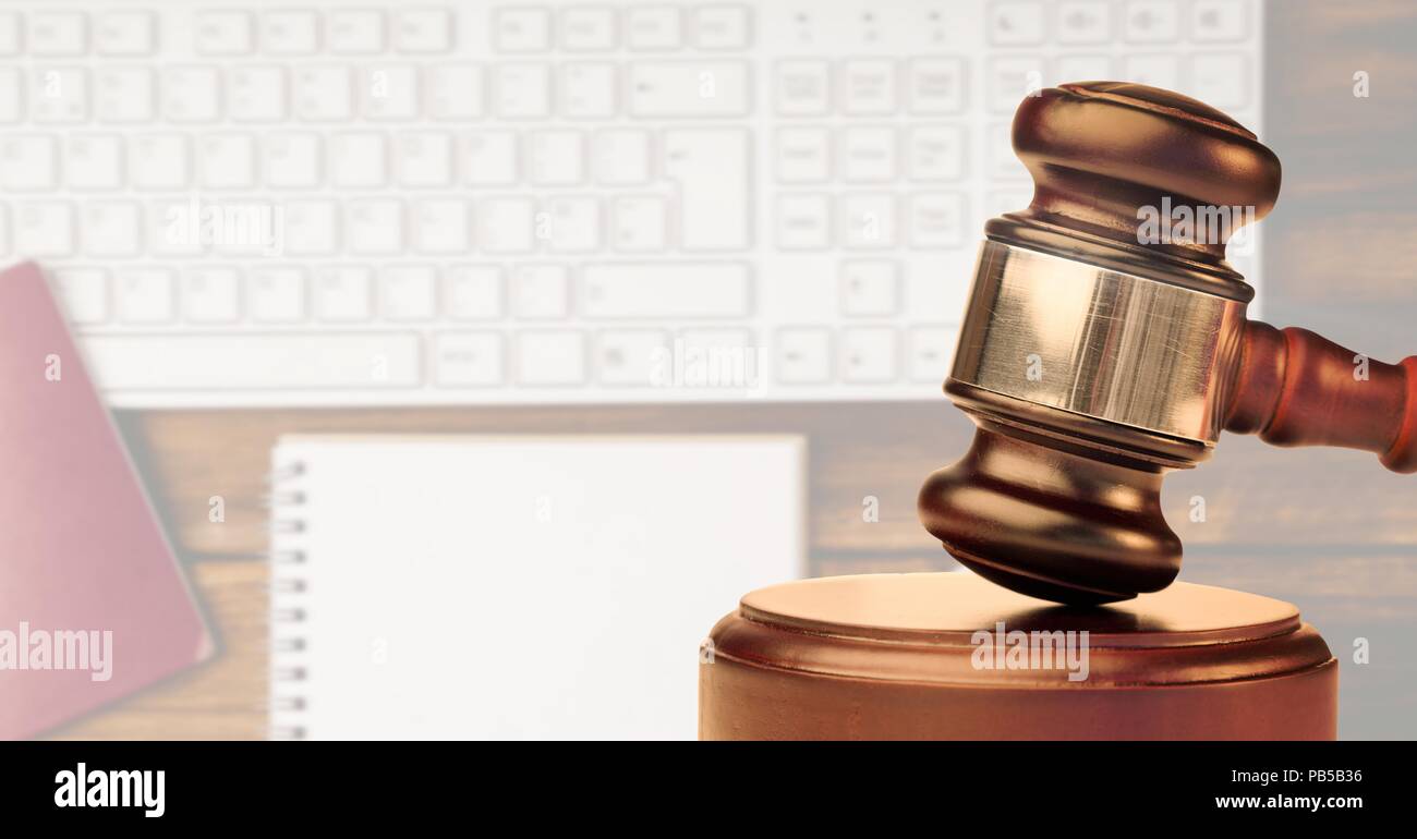 Gavel with keyboard and notebook in background Stock Photo