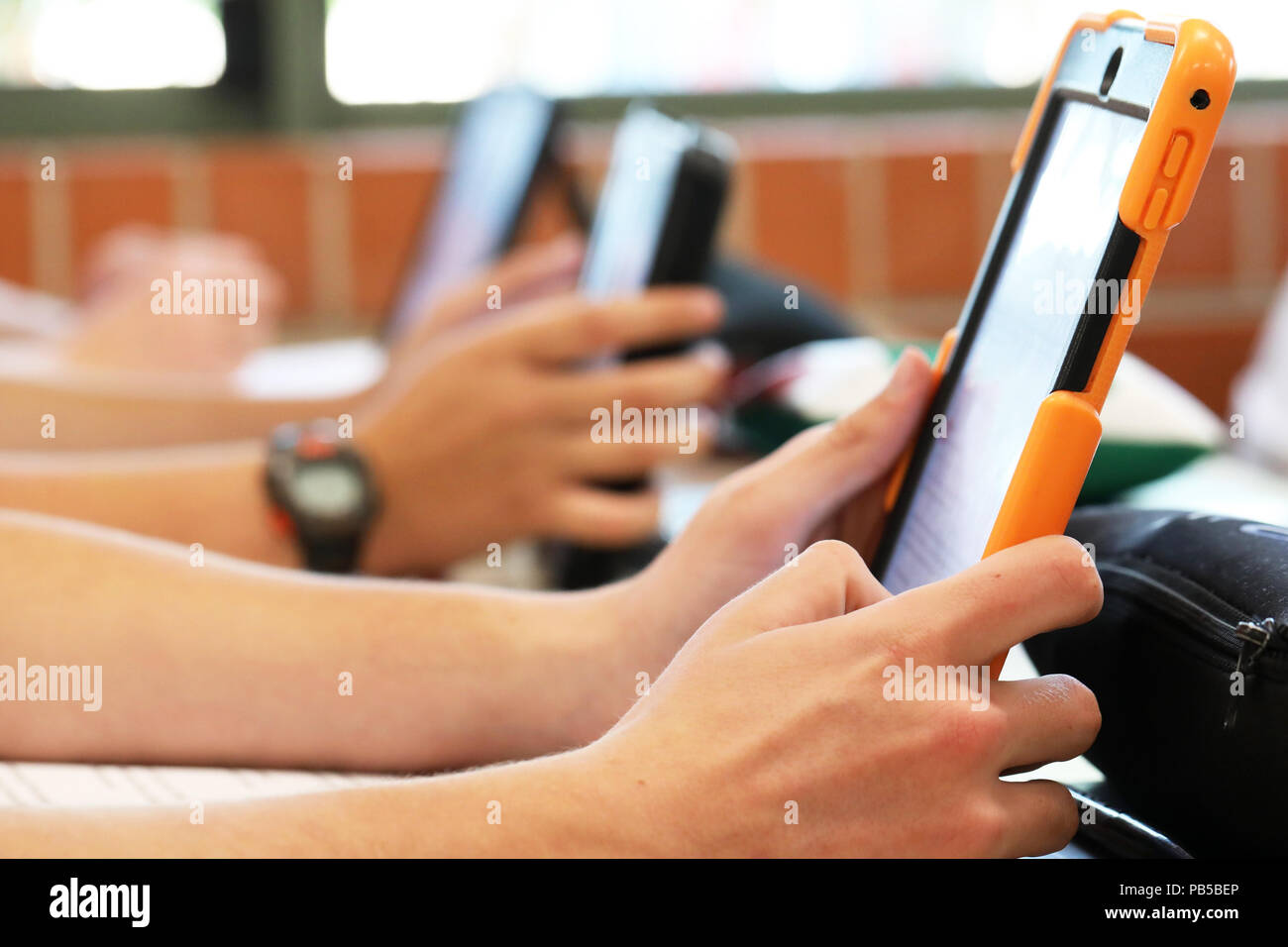 High school students working on using an ipad tablet style electronic