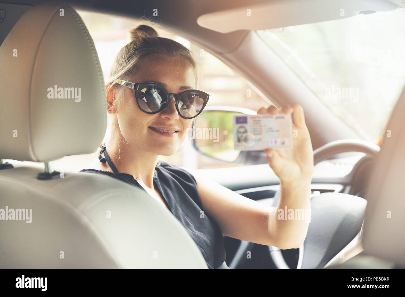 woman showing her new driver license in a car Stock Photo