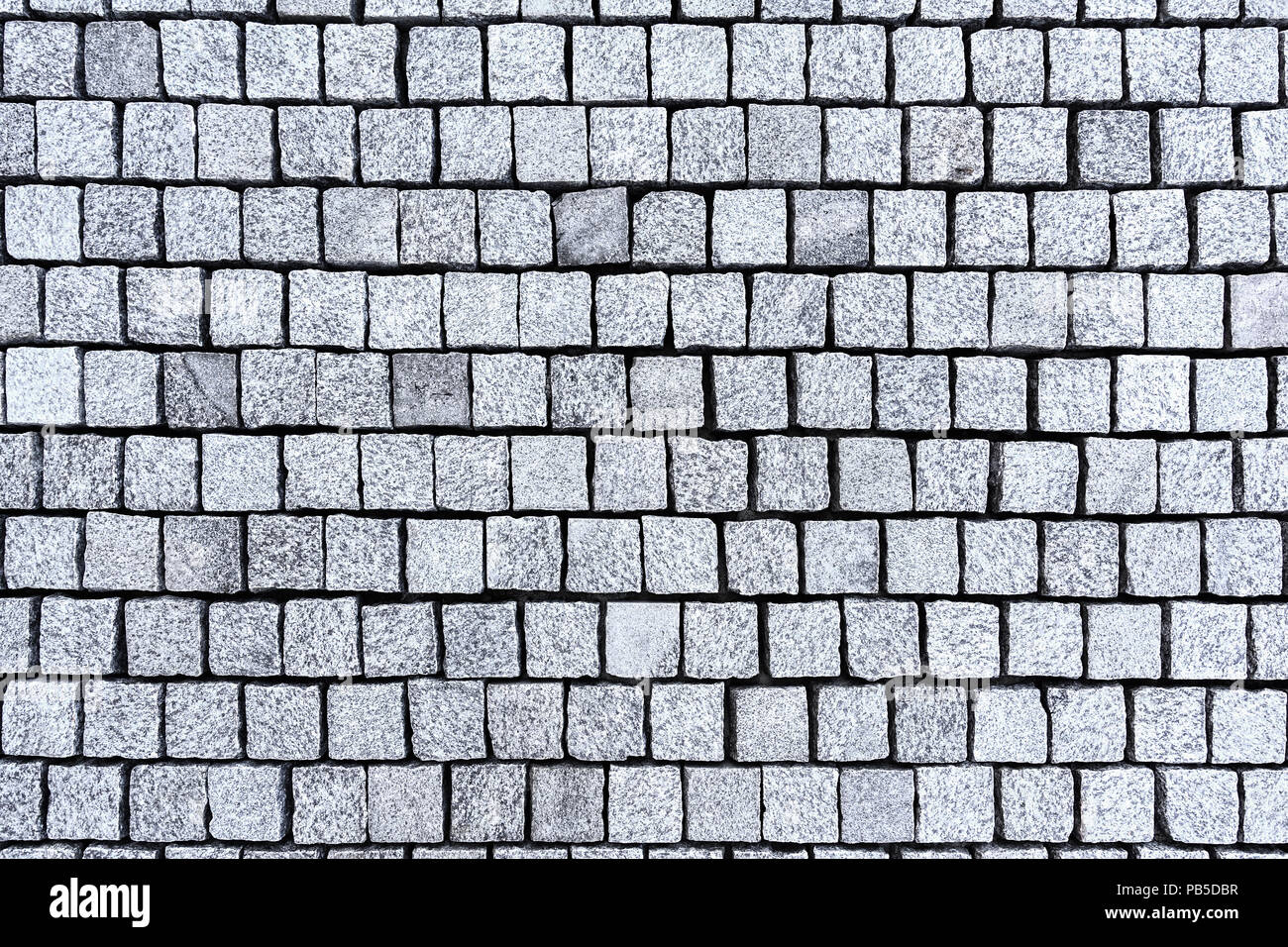 Grey cobble stones paved in lines as a background image. Stock Photo