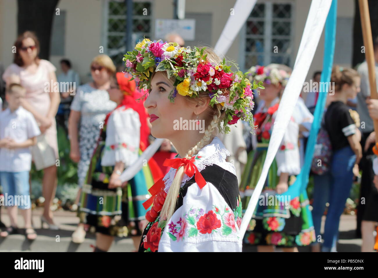 Beautiful Polish girl blond hair braid, head decorated with flowers wreath, dressed in folk costume,annual Corpus Christi procession in lowicz, poland Stock Photo