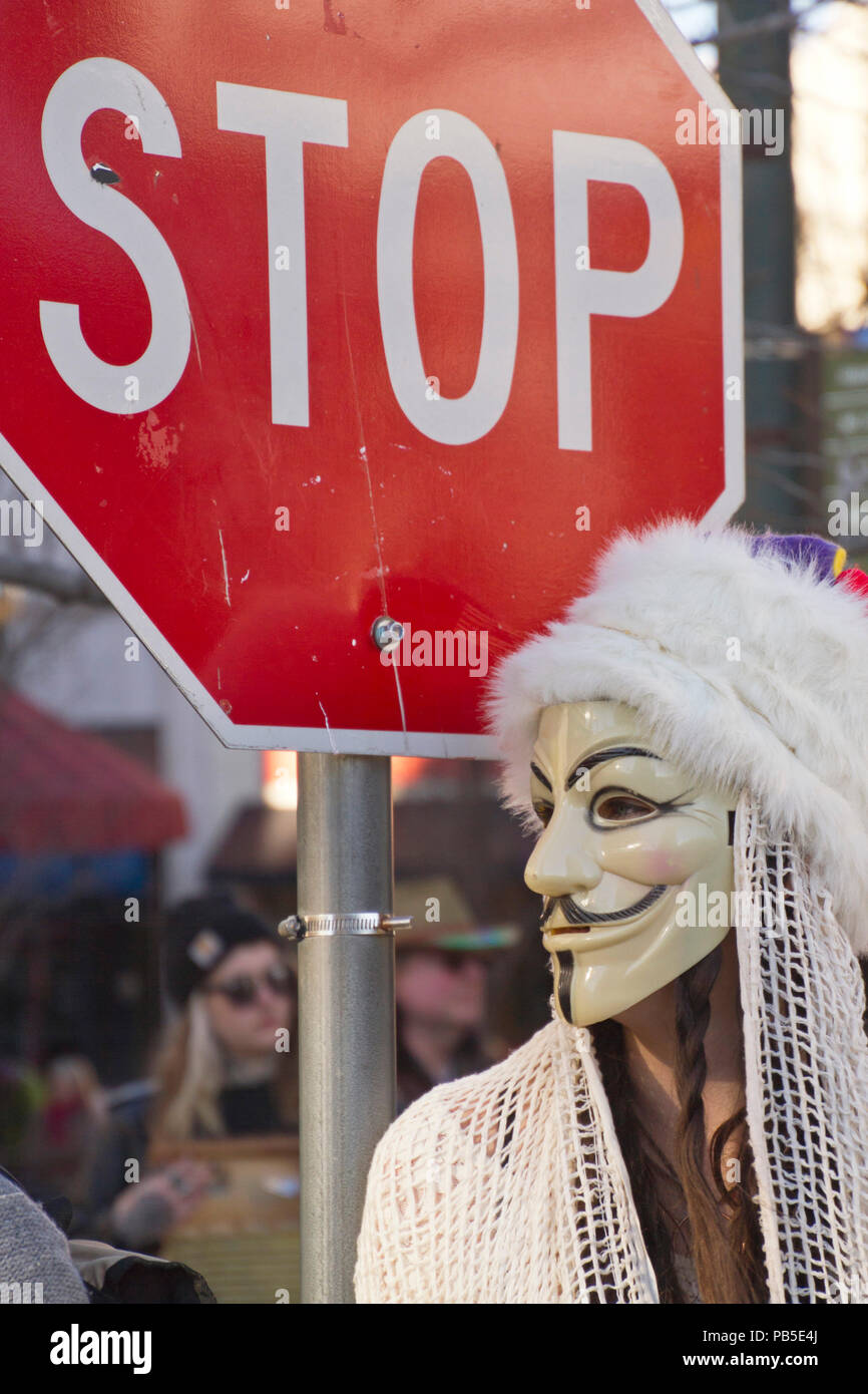 Asheville North Carolina Usa February 7 2016 Young Woman Wearing A Guy Fawkes Mask Stands By A Stop Sign In The 2016 Mardi Gras Parade Stock Photo Alamy