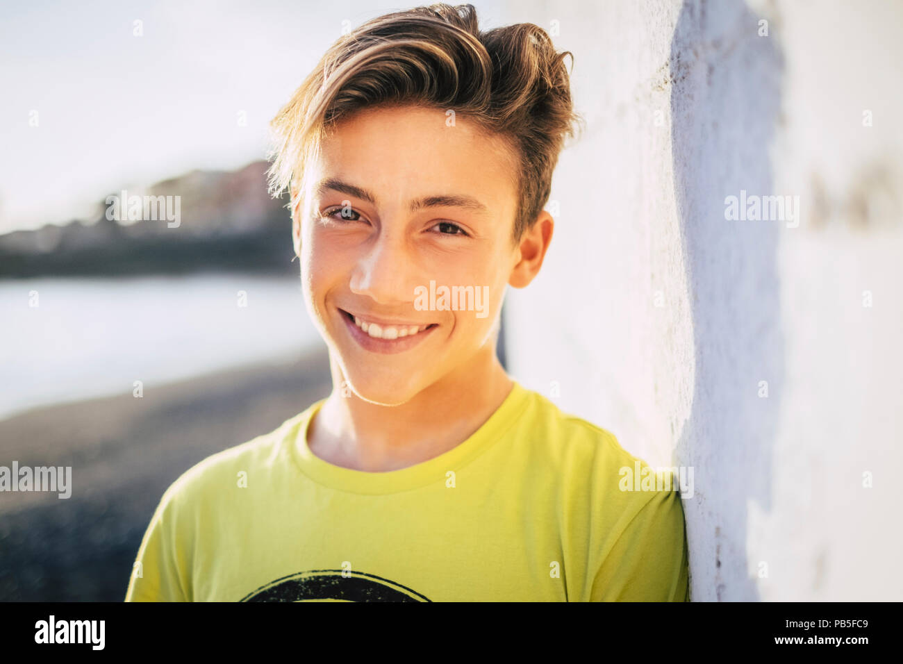 young beautiful male teenager smile outdoor with a blue sky background. summer style concept image Stock Photo