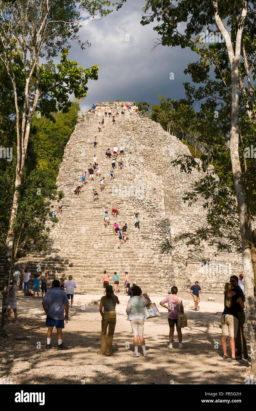 Tourists climb the Great Pyramid Nohoch Mul at the Coba archeological site in Quintana Roo state in Southern Mexico. Stock Photo