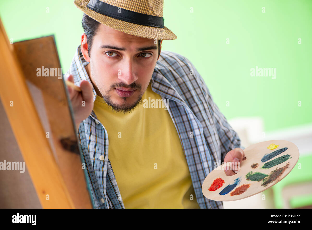 Young male artist working on new painting in his studio Stock Photo - Alamy