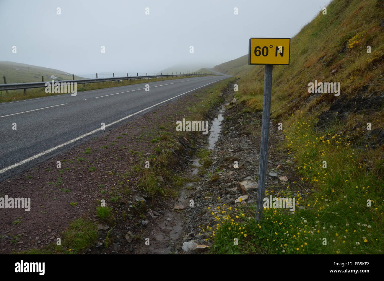 A sign marking the point where the A970 road crosses the 60 degrees north line of latitude, in Shetland, British Isles, UK Stock Photo