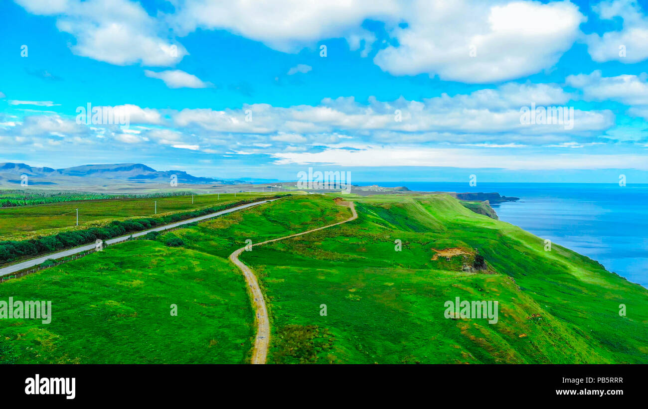 Aerial view over the green coastline and cliffs on the Isle of Skye in ...