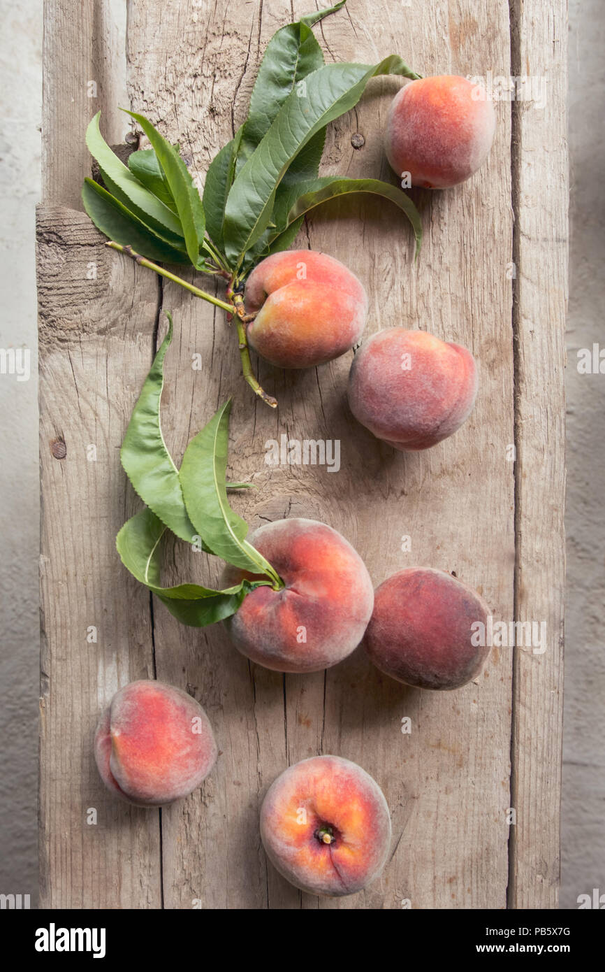 Peaches gathered from the garden on a wooden background Stock Photo