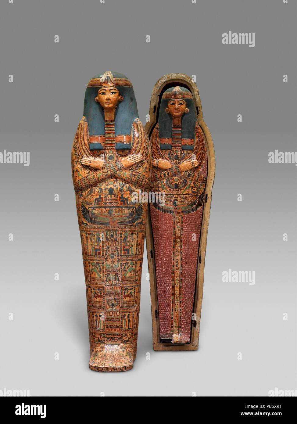 Mummy Board of the Singer of Amun-Re, Henettawy. Dimensions: L. 171.3 cm (67 7/16 in.); W. 40 cm (15 3/4 in.); D. 16 cm (6 3/8 in.). Dynasty: late Dynasty 21. Date: ca. 1000-945 B.C..  Henettawy's principal burial equipment consisted of two splendid coffins (25.3.182a, b; 25.3.183a, b) and a mummy board (25.3.184). The coffins and the mummy board are all shaped like wrapped mummies with elaborate masks fastened over the heads.  The mummy board has no pectoral on a necklace. There are, however, two emblems of the scarab that pushes the sun disk, the lower one flanked by two Re-Harakhty falcons  Stock Photo