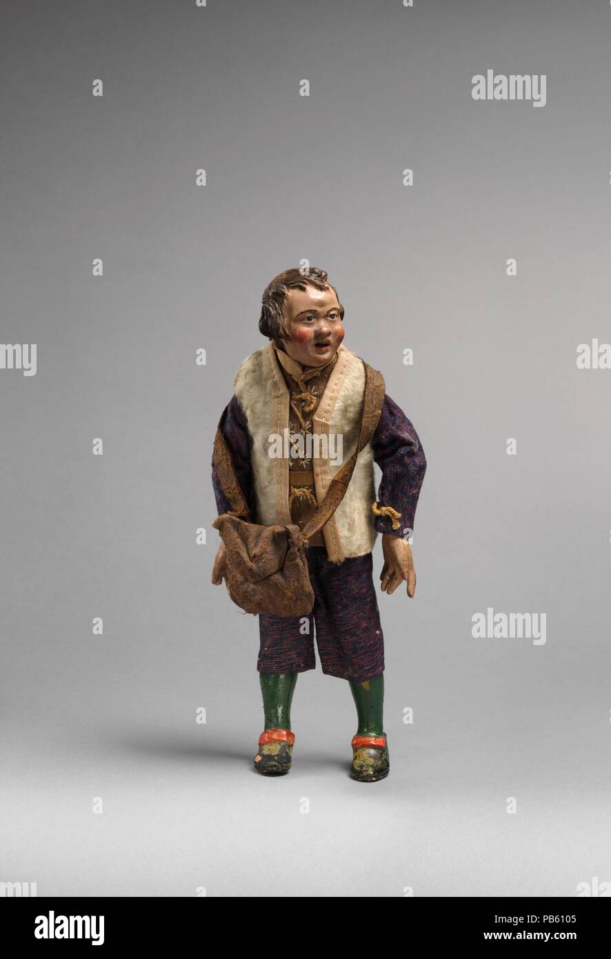 Small man with white furry vest, blue/purple suit, green painted leggings. Culture: Italian. Dimensions: Overall (confirmed): 9 × 3 3/4 × 2 in. (22.9 × 9.5 × 5.1 cm). Date: second half 18th-mid-19th century.  The practice of using crèche figures to restage religious events reached the height of its complexity and artistic excellence in eighteenth-century Naples, and the Metropolitan Museum of Art's group of Neapolitan crèche is one of the finest and most complete survivals of the art form. The ensemble consists of characters traditional to eighteenth-century Italian Christmas holiday customs.  Stock Photo