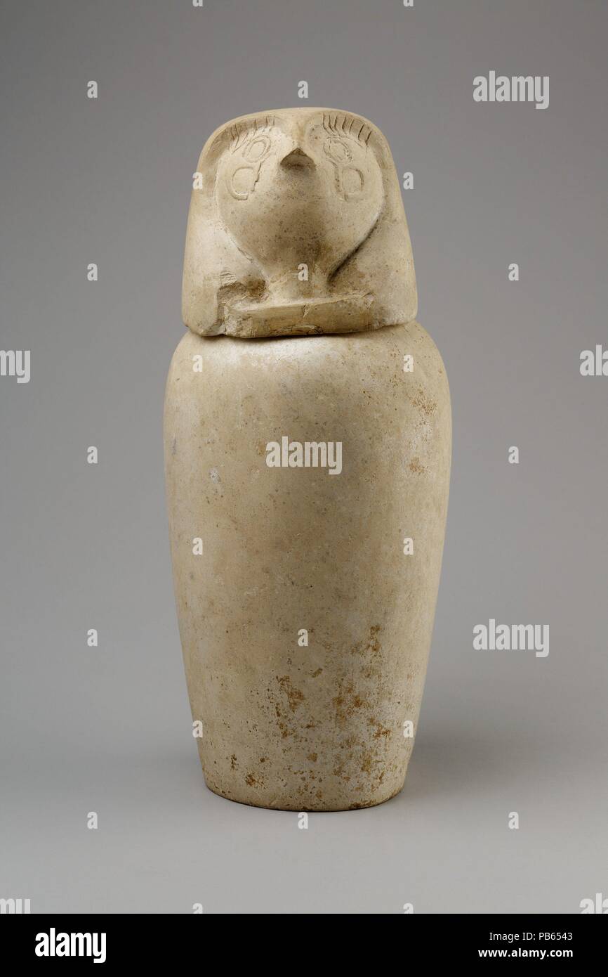 Canopic jar with falcon head (Qebehsenuef). Dimensions: Jar: H. 25.5 cm (10 1/16 in.); d. 17.3 cm (6 13/16 in.); diam. of mouth 8 cm (3 1/8 in.); diam. of base 10.5 cm (4 1/8 in.); circ. 47 cm (18 1/2 in); Lid: H. 13 cm (5 1/8 in.); diam. 12.4 cm (4 7/8 in.); diam. of foot 6.5 cm (2 9/16 in.); Jar with Lid: H. 35.5 cm (14 in.); diam. 14.7 cm (5 13/16 in.). Date: ca. 800-650 BC.  This canopic is part of a set (13.180.1--.4) found in a Ptolemaic cemetery at Thebes. Use of canopics had gone out of fashion at that period, however, so these are certainly reused. Their style suggests they were origi Stock Photo