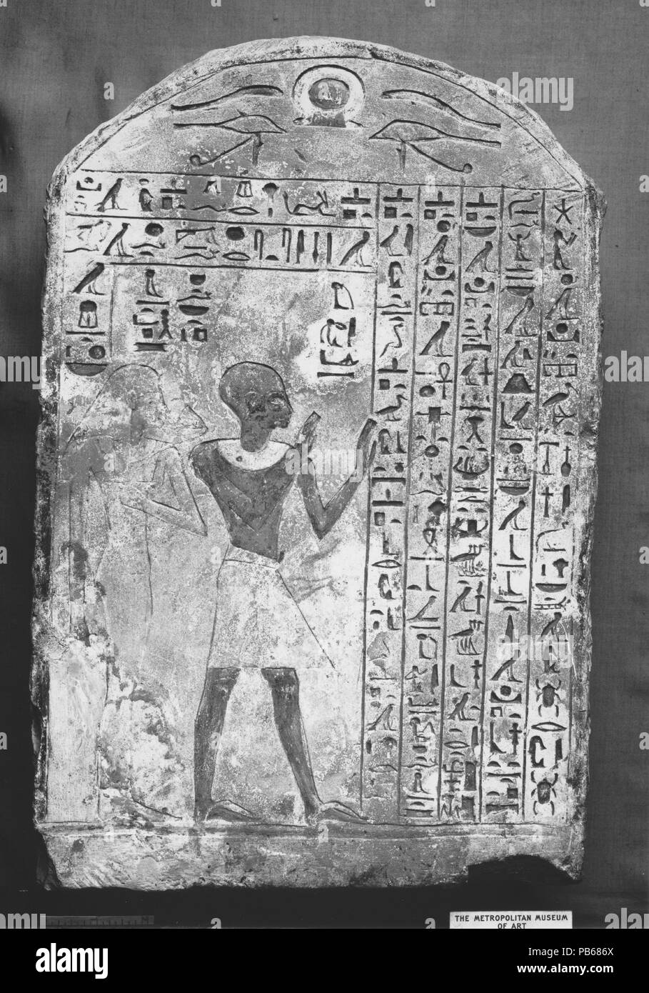 Stela of Ameny and his Wife Inethapy. Dimensions: H. 42.5 cm (16 3/4 in); w. 27.5 cm (10 13/16 in). Dynasty: Dynasty 18. Reign: reign of Thutmose I-Amenhotep II. Date: ca. 1427-1400 B.C..  The wab priest Ameny is shown with upraised arms, a pose of adoration. He is followed by his wife, Inet-Hapy, who holds a lotus flower. The text invokes the gods Re-Horakhty, Thoth, Atum, and Khepri. Museum: Metropolitan Museum of Art, New York, USA. Stock Photo