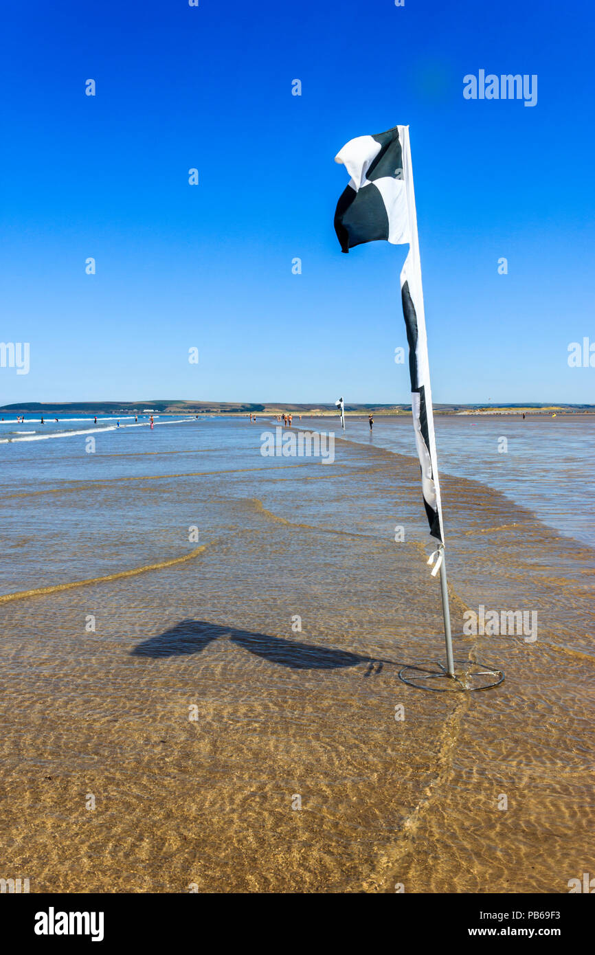 RNLI Safety marker flags on the beach at Westward Ho!, Devon, UK Stock