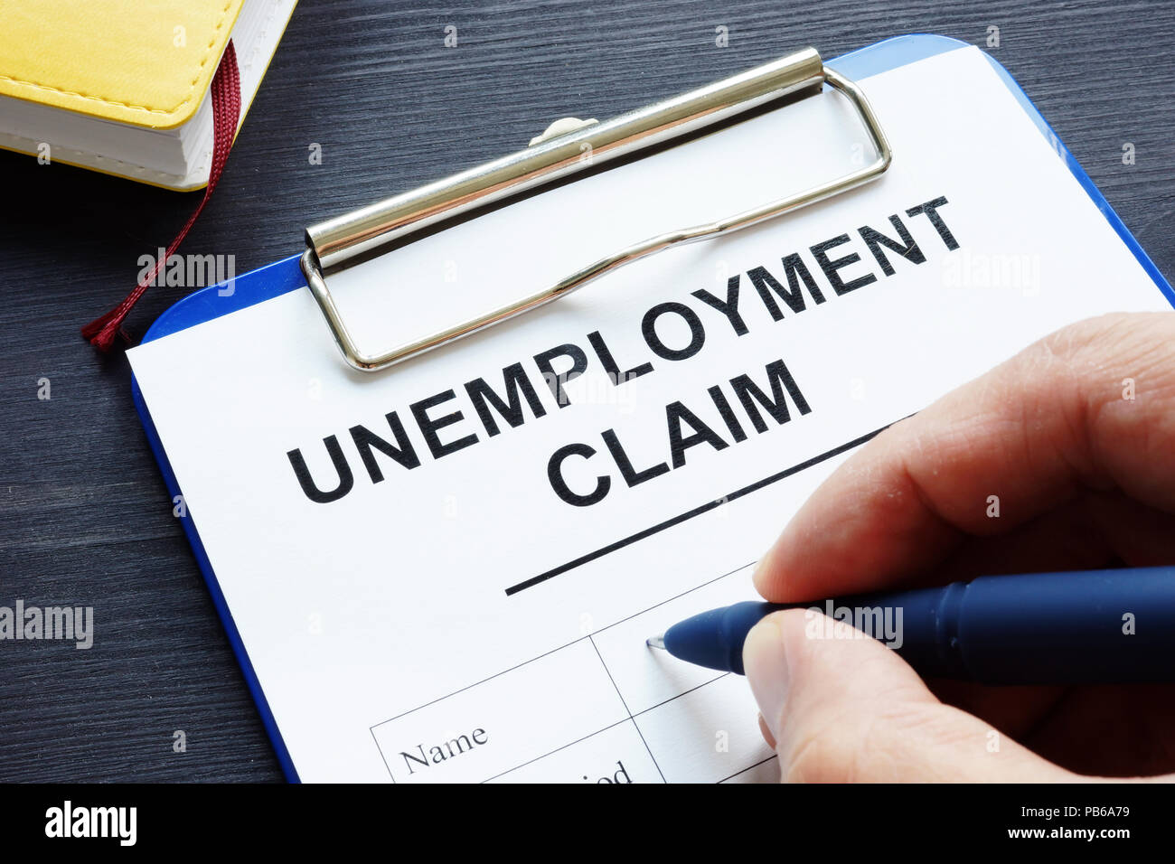 Man is filling in Unemployment claim form. Stock Photo