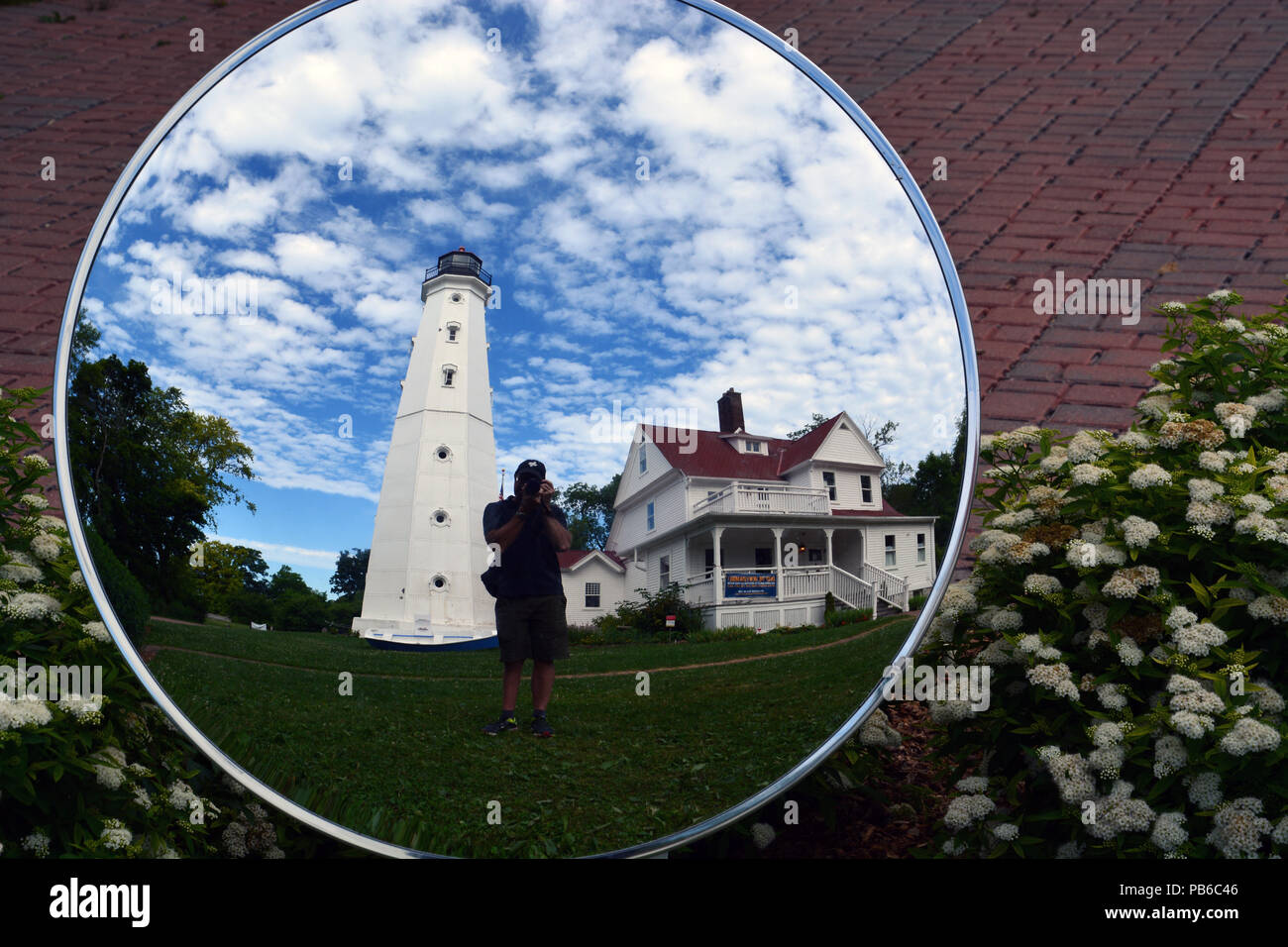A visitor takes a picture in the selfie mirror at the North Point Light Station north of downtown Milwaukee. Stock Photo