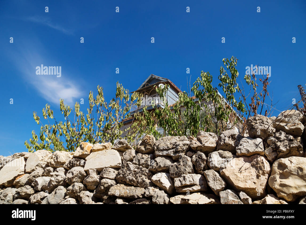 Traditional lebanese house with green dry fence with blue sky in Rachaiya, Bekaa valley, Lebanon Stock Photo