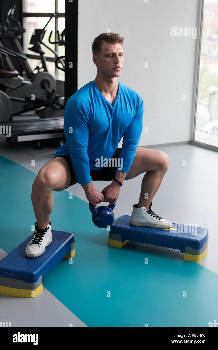Young Man Exercising With Kettle Bell And Flexing Muscles - Muscular ...