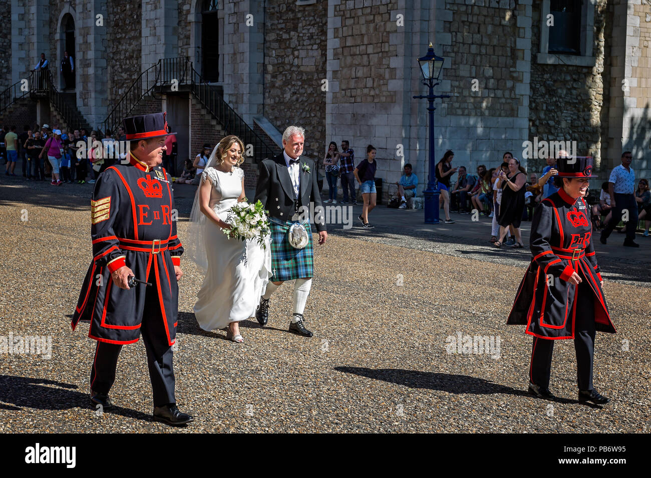 Bride & father of the bride escorted by beefeaters on way to wedding, taken in Tower of London, London, UK on 8 July 2017 Stock Photo