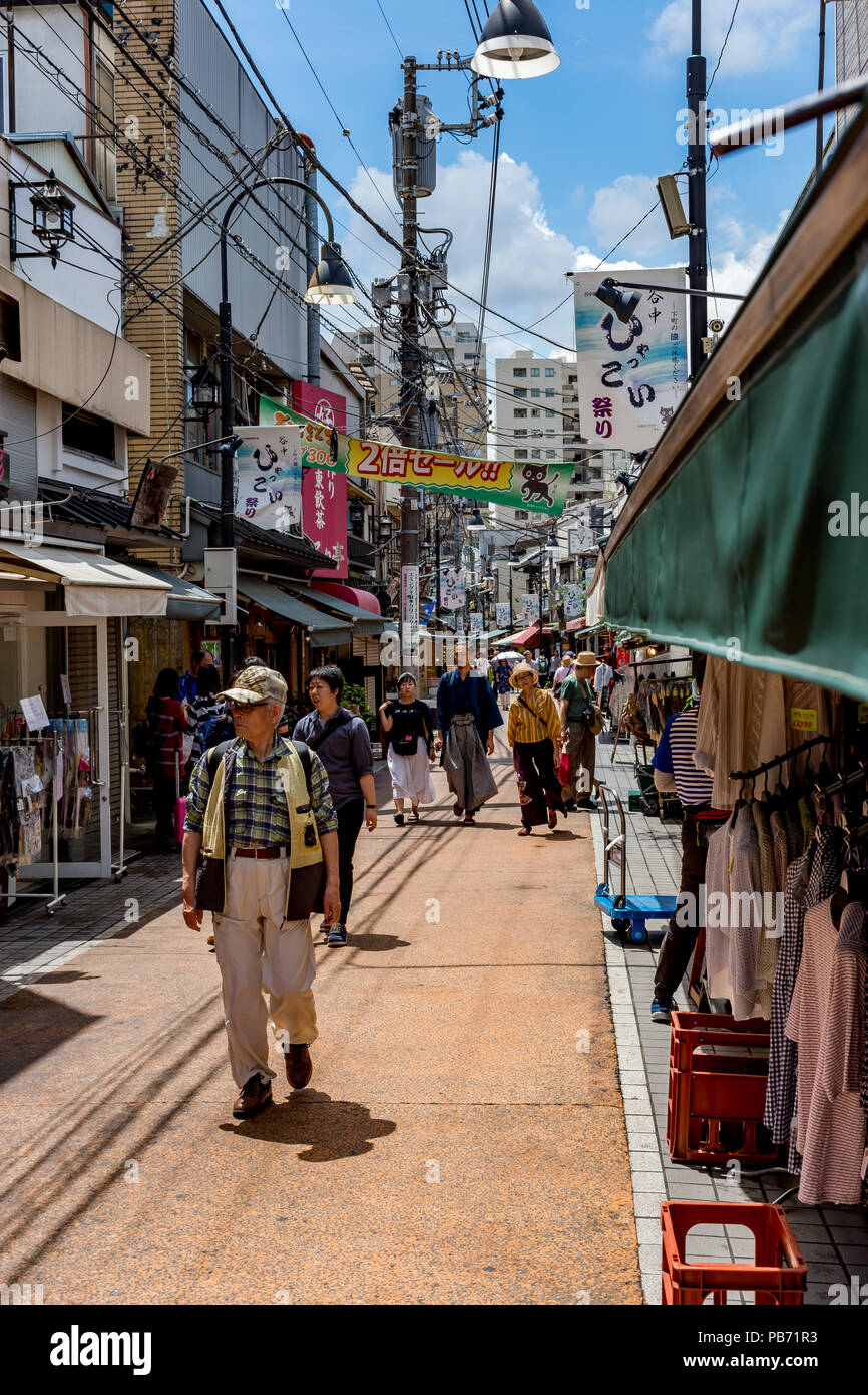 Japanese middle aged tourists stroll through a small side street in Tokyo. Stock Photo