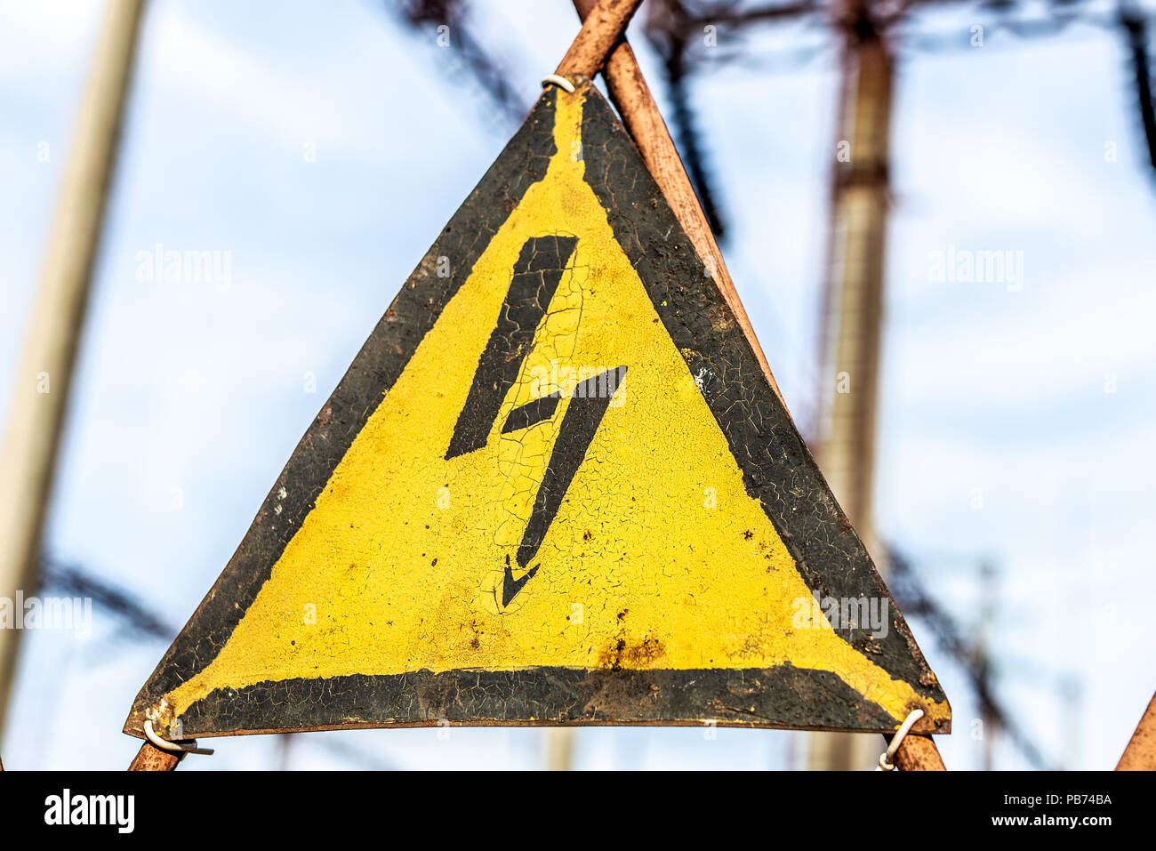 Closeup old aged rusty triangle metal plate with High voltage warning