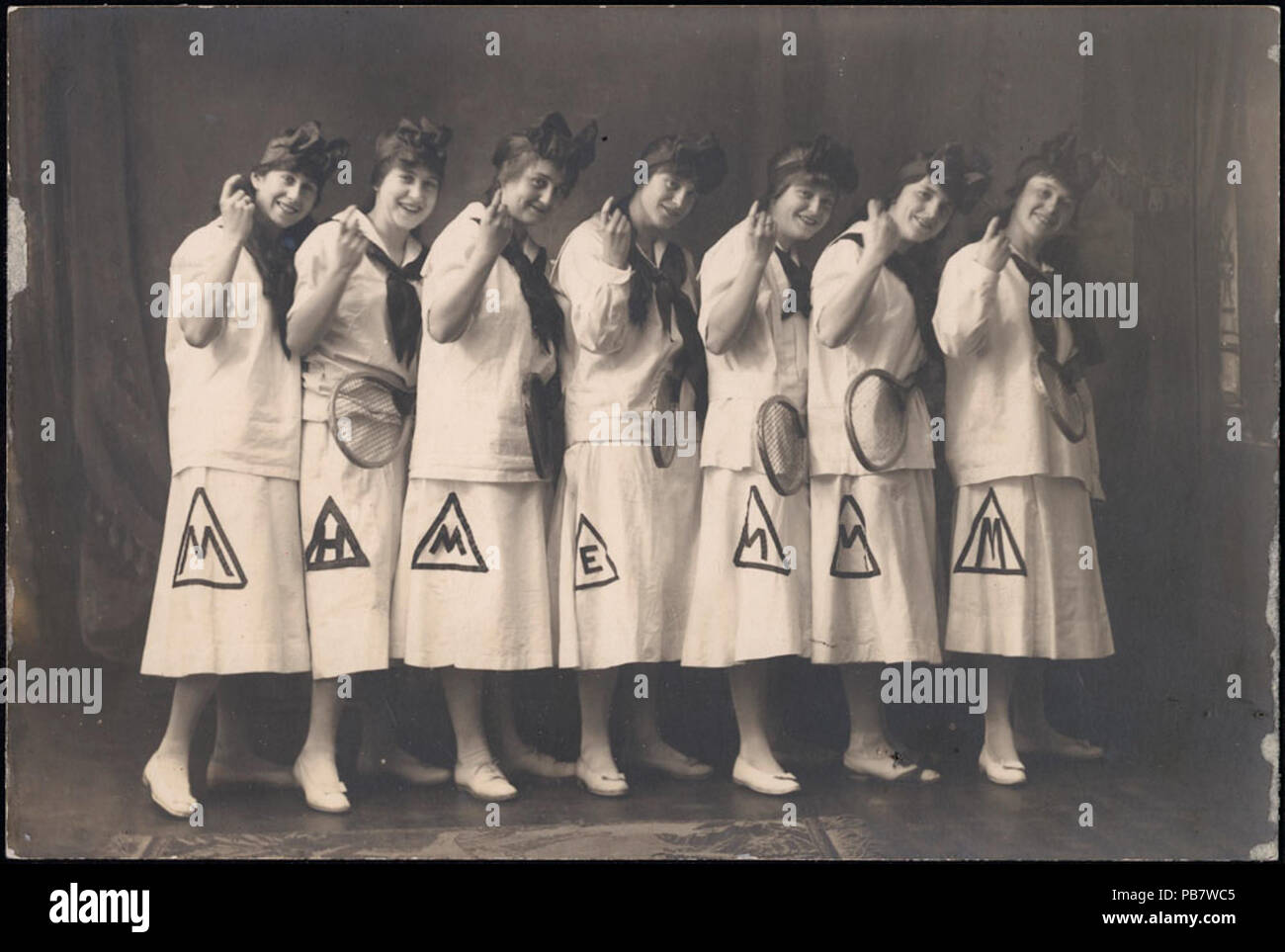 1309 Seven women in sports dress holding tennis rackets - team photo Stock Photo
