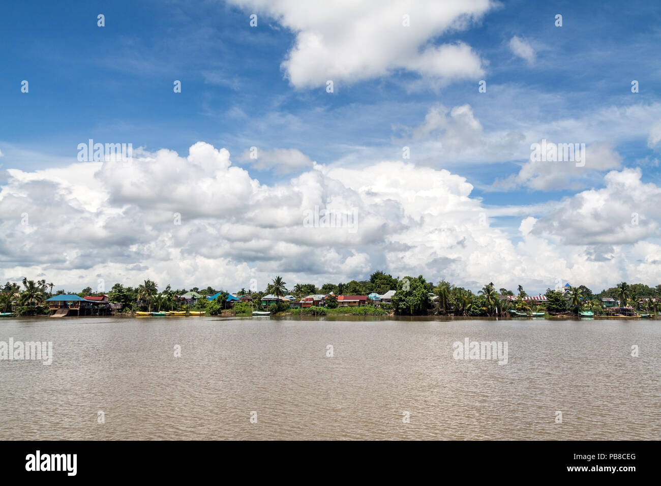 The Sarawak River with traditional rural scenics on the riverside. A beautiful wide angle landscape image of real life conditions in Malaysian Borneo. Stock Photo