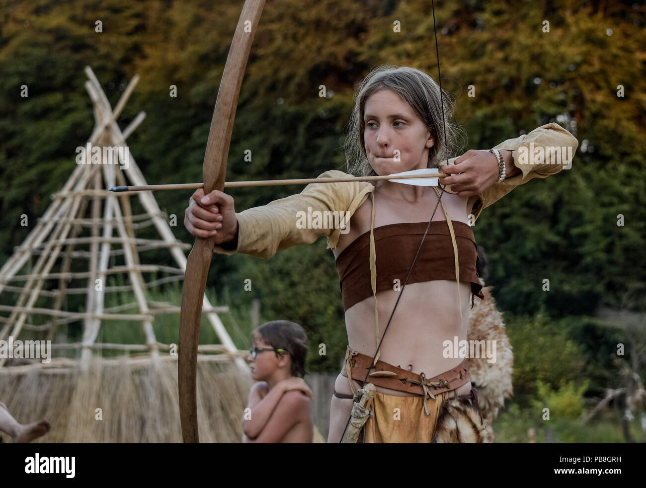 Albersdorf, Germany. 24th July, 2018. A woman practices archery with a self-made bow. Around 80 men, women and children met in Alberdorf in the district of Dithmarschen under the motto "largest Stone Age meeting since the Stone Age". Credit: Axel Heimken/dpa/Alamy Live News Stock Photo