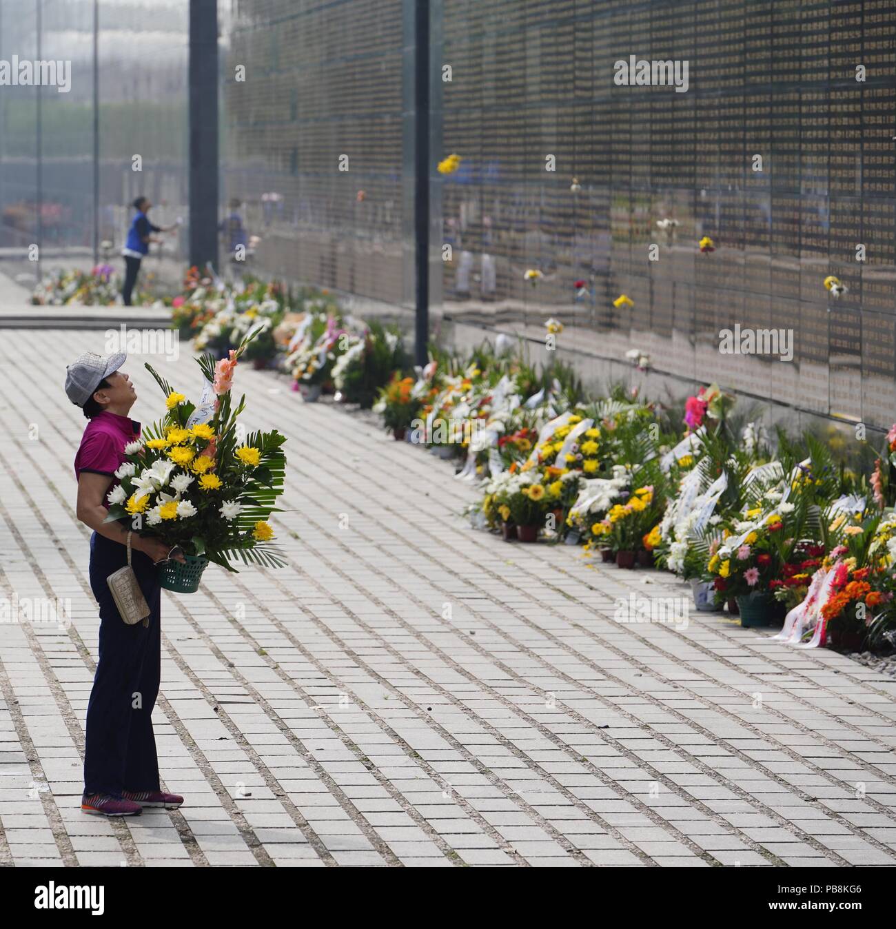 Tangshan. 27th July, 2018. People mourn for relatives killed in the 1976 Tangshan earthquake in front of the memorial wall in Tangshan, north China's Hebei Province, July 27, 2018, one day before the 42nd anniversary of the earthquake. Credit: Dong Jun/Xinhua/Alamy Live News Stock Photo