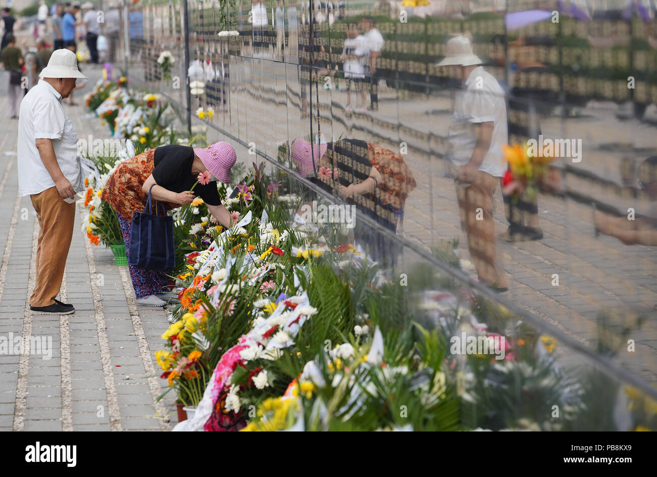 Tangshan. 27th July, 2018. People mourn for relatives killed in the 1976 Tangshan earthquake in front of the memorial wall in Tangshan, north China's Hebei Province, July 27, 2018, one day before the 42nd anniversary of the earthquake. Credit: Dong Jun/Xinhua/Alamy Live News Stock Photo