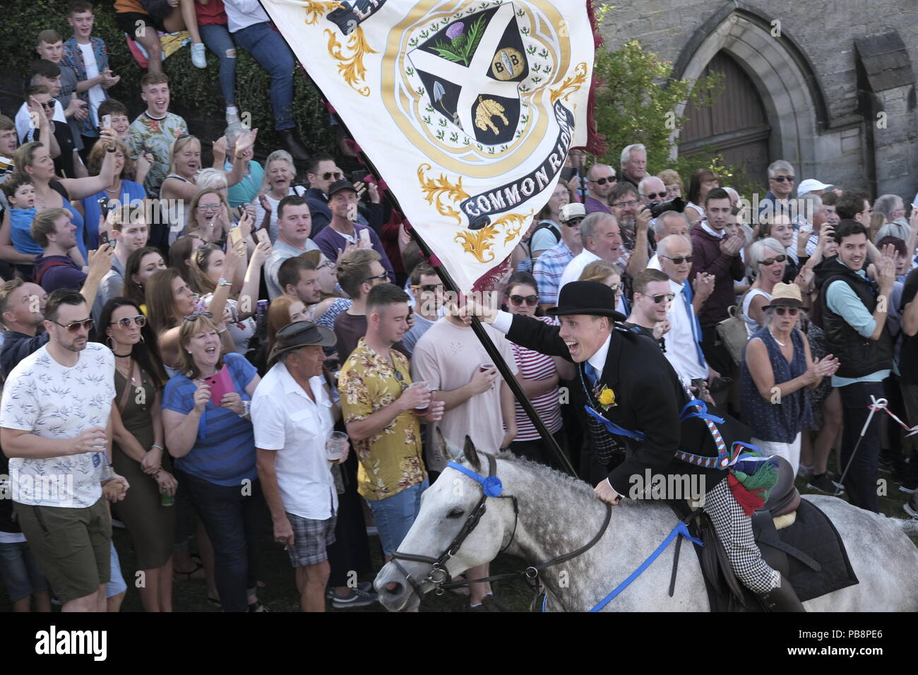 Langholm, Scotland, UK. 27th July, 2018.  Langholm Common Riding - 'Langholm's Great Day' Langholm Cornet Iain Little gallops up the Kirk Wynd ahead of his mounted supporters in Langholm, 'The Muckle Toon' has seen tradition upheld for over 250 years with the Annual Langholm Common Riding which takes place every year on the last Friday in July, This year falling on Friday 27th.   Credit: Rob Gray/Alamy Live News Stock Photo
