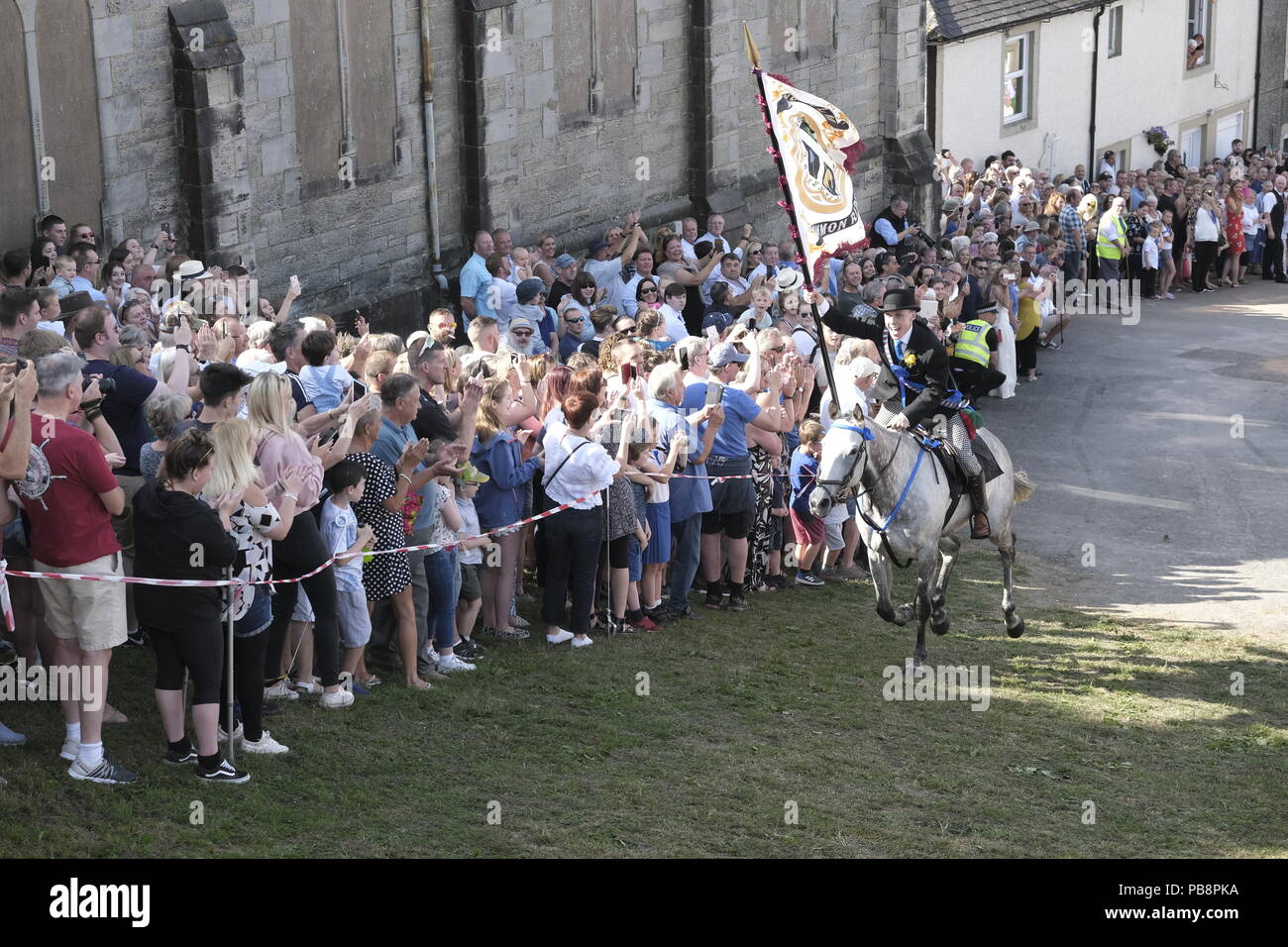 Langholm, Scotland, UK. 27th July, 2018.    Langholm Common Riding - 'Langholm's Great Day' Langholm Cornet Iain Little gallops up the Kirk Wynd ahead of his mounted supporters in Langholm, 'The Muckle Toon' has seen tradition upheld for over 250 years with the Annual Langholm Common Riding which takes place every year on the last Friday in July, This year falling on Friday 27th.   Credit: Rob Gray/Alamy Live News Stock Photo