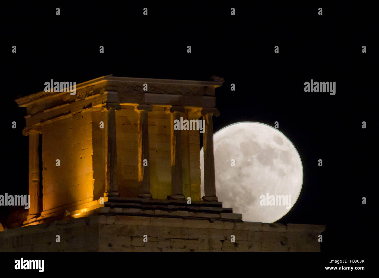 Athens, Greece. 27th July, 2018. Full moon rises over the ancient Temple of  Athena Nike in Acropolis, The complete lunar eclipse Friday when the sun,  Earth and moon line up perfectly to