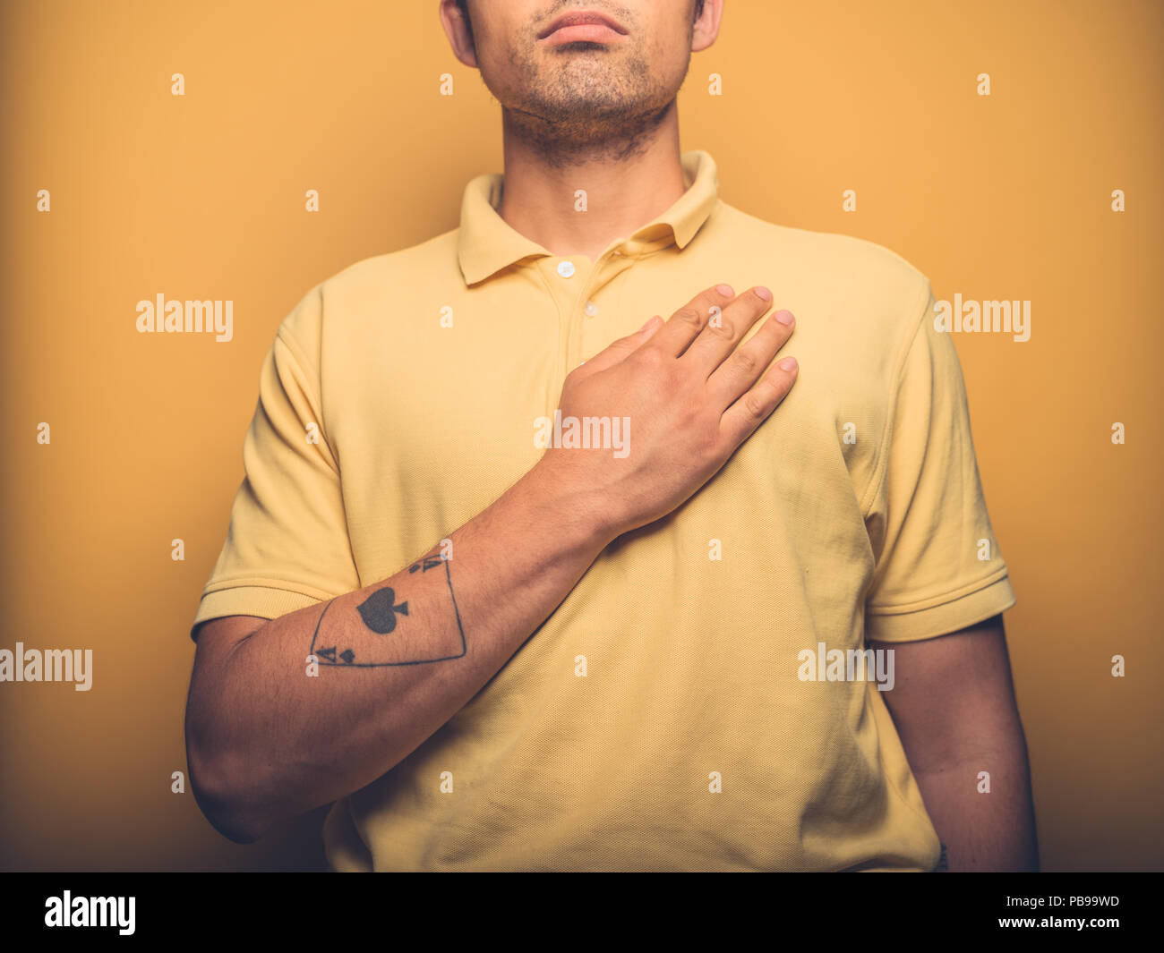 A young man is swearing allegiance with his hand on his chest Stock Photo
