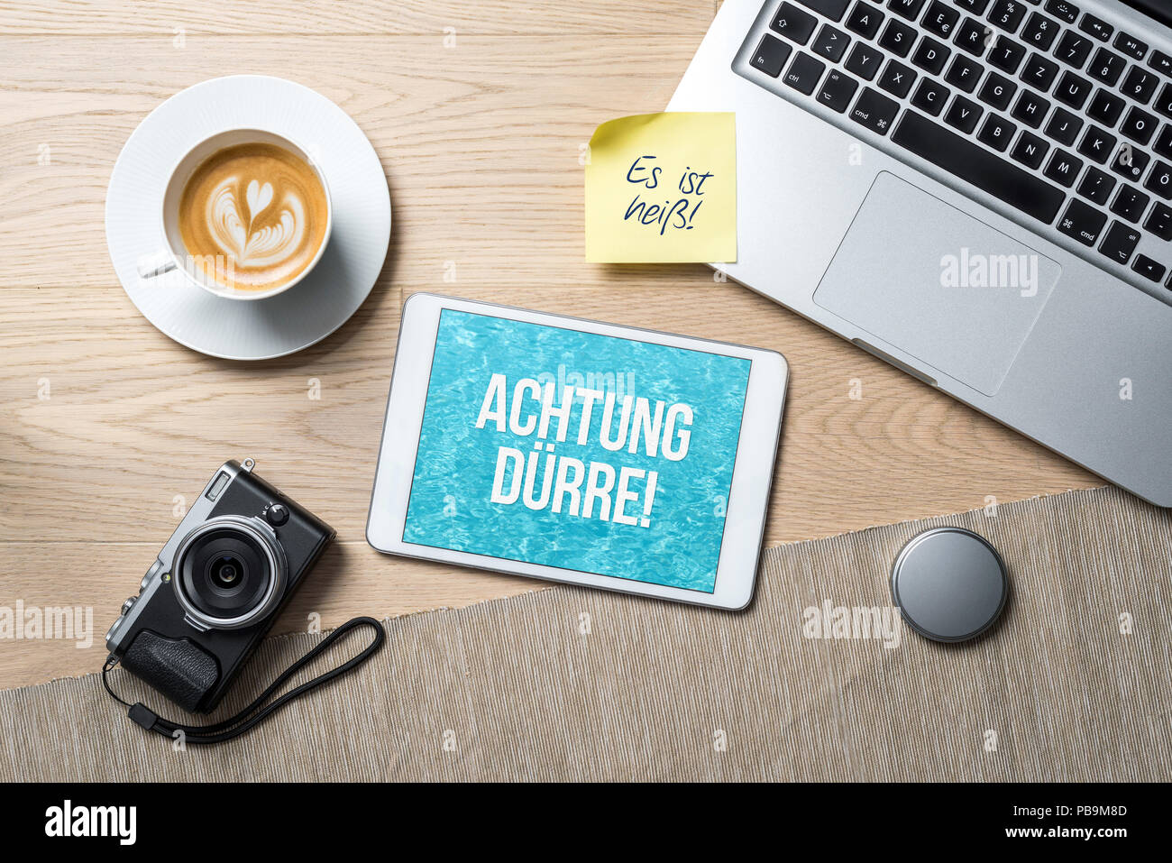 Attention drought due to a heat wave written in german on tablet during the summer of the century 2018 on office desk as flatlay from above Stock Photo