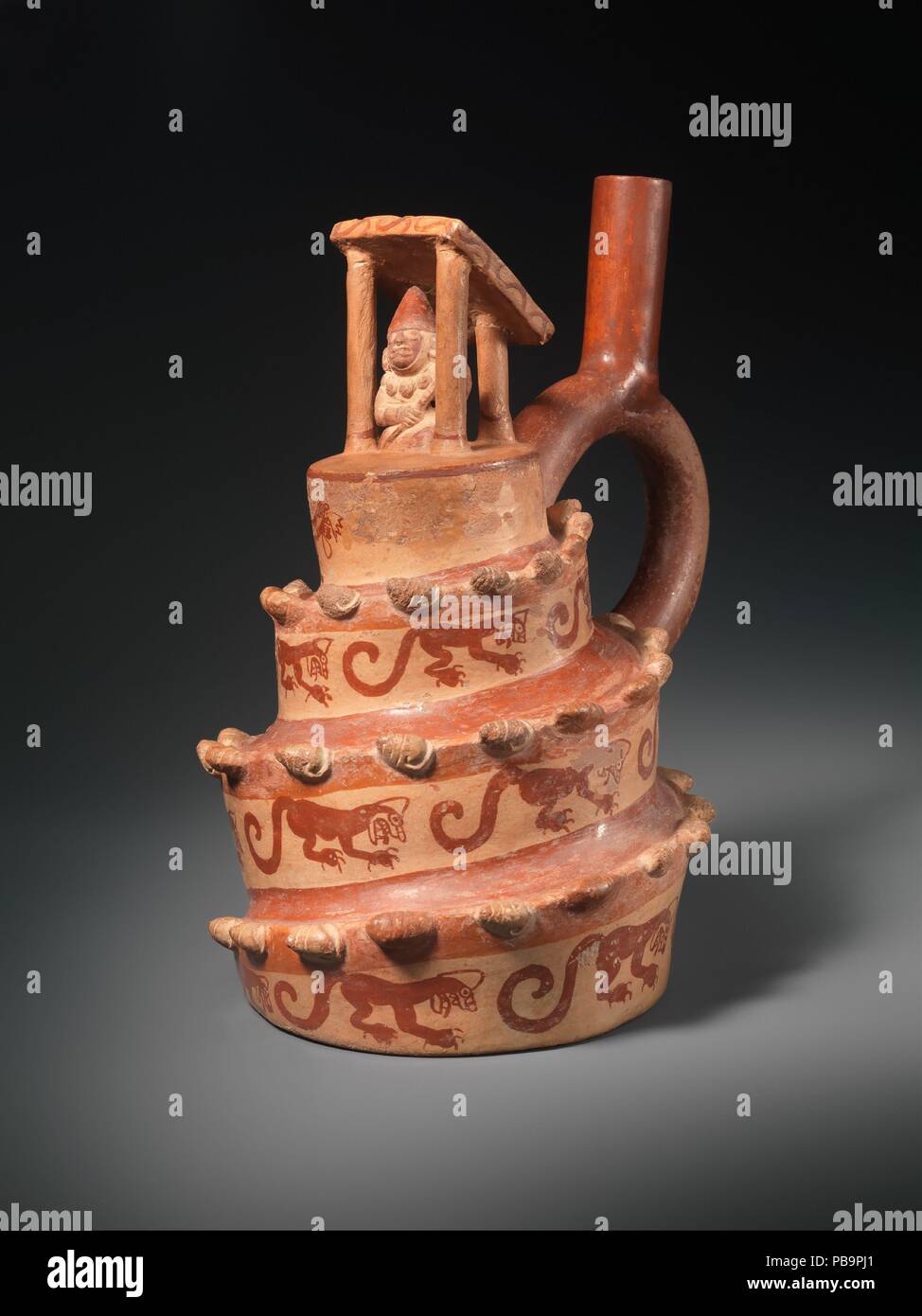 Architectural Vessel. Culture: Moche. Dimensions: H. 8 7/16 x W. 5 1/2 in. (21.51 x 13.97 cm). Date: A.D. 400-600.  This vessel is modeled in the shape of a spiral platform surmounted by an open-sided structure with a figure inside. The vessel itself is a bottle, with a spout in the shape of a stirrup, a characteristic shape on Peru's north coast from the first millennium B.C. through the later part of the first millennium A.D. The spiral platform is ornamented with a procession of snails, sculpted in high relief, and felines, painted in red slip, ascending to the summit where a figure is depi Stock Photo