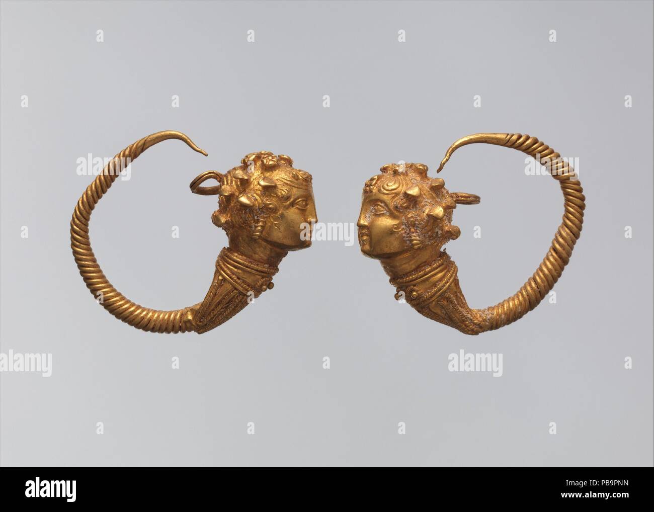 Maenad-head earrings. Dimensions: a. As Worn: H. 2.5 × W. 2.9 cm (1 × 1 1/8 in.)  b. As Worn: H. 2.4 × W. 2.7 cm (15/16 × 1 1/16 in.). Date: 1st century B.C..  Earrings with heads of maenads (Dionysus's female followers) are rare in Egypt but occur in the Levant and Cyprus. The form is late Hellenistic. Museum: Metropolitan Museum of Art, New York, USA. Stock Photo