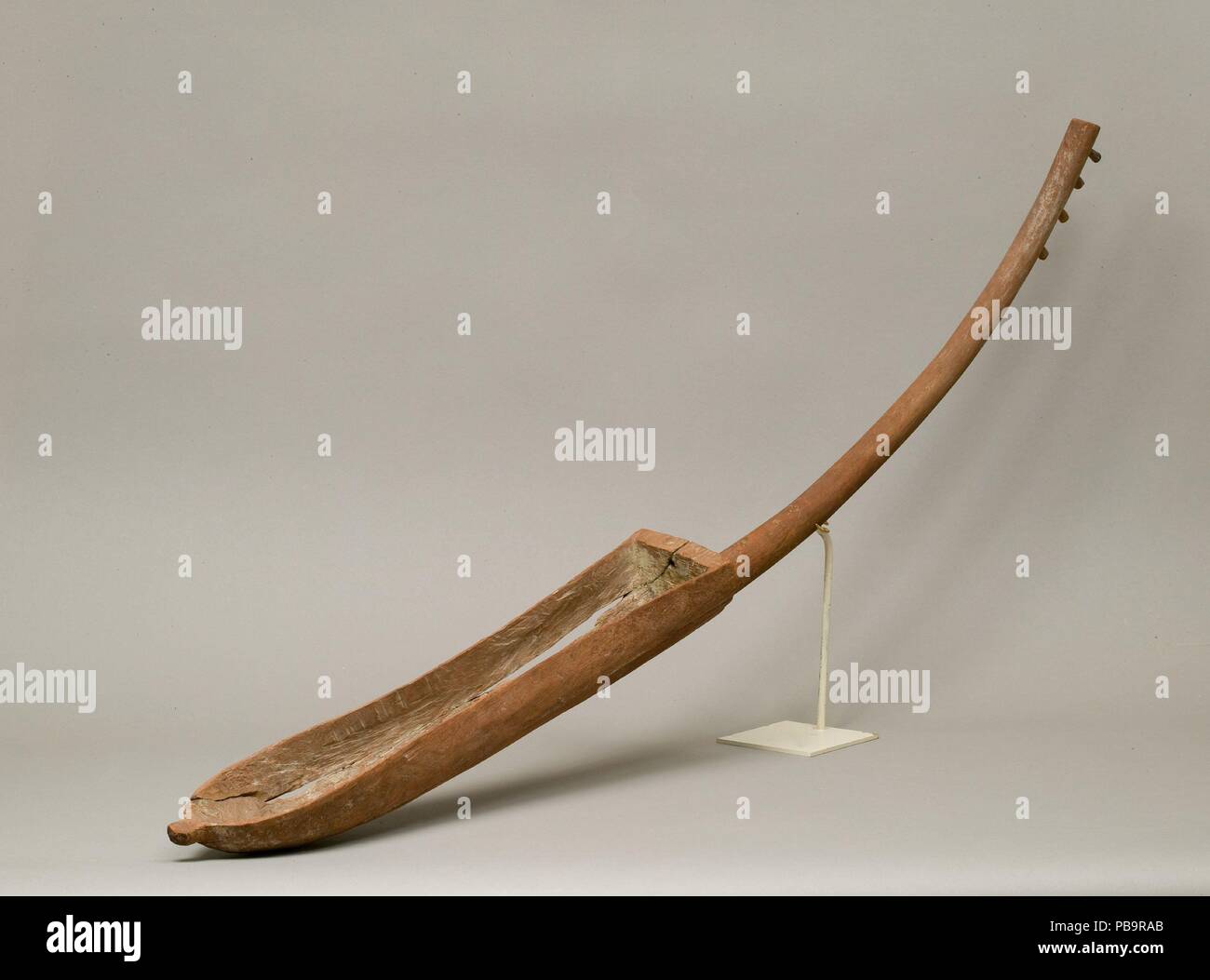 Harp. Dimensions: l. 110 cm (43 5/16 in). Dynasty: late Dynasty 13-early Dynasty 18. Date: ca. 1700-1450 B.C..  Arched harps of this type were already in use during the Old Kingdom and remained the foremost string instruments until the end of the Middle Kingdom. From the New Kingdom onward, Egyptian arched harps co-existed with a great variety of harps in different shapes and sizes. Unlike modern European versions, ancient Egyptian harps have no forepillar to strengthen and support the neck.  Skin, now missing, covered the open top of the soundbox. Older forms of arched harps like this had fou Stock Photo