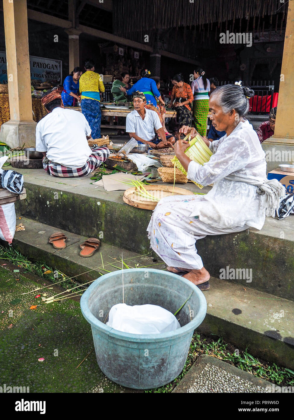 Ubud, Bali - April 2017: Old woman making bamboo baskets called canang sari for Nyepi festival in a local temple Stock Photo