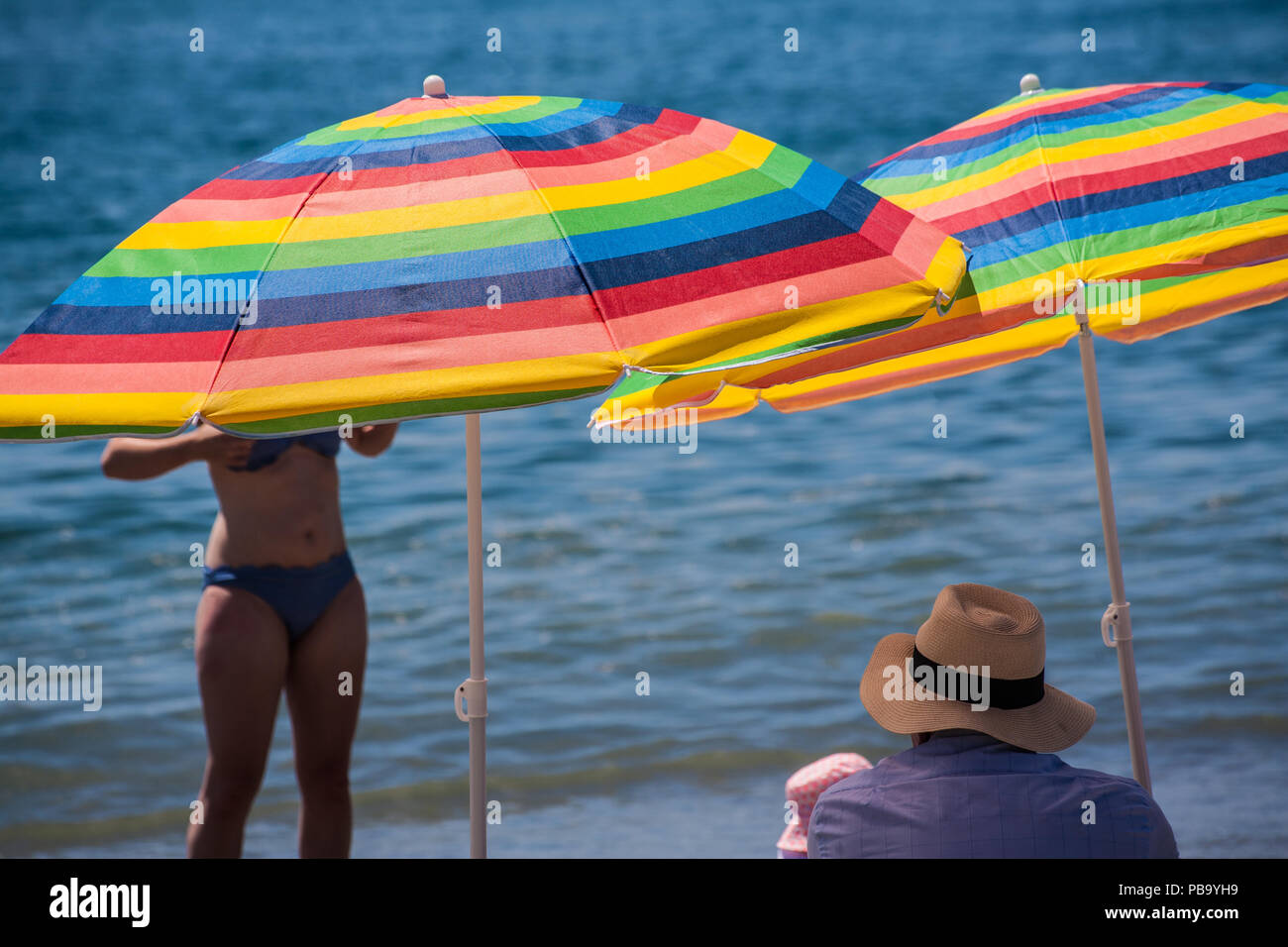 brightly colored parasols on Spanish beach Stock Photo