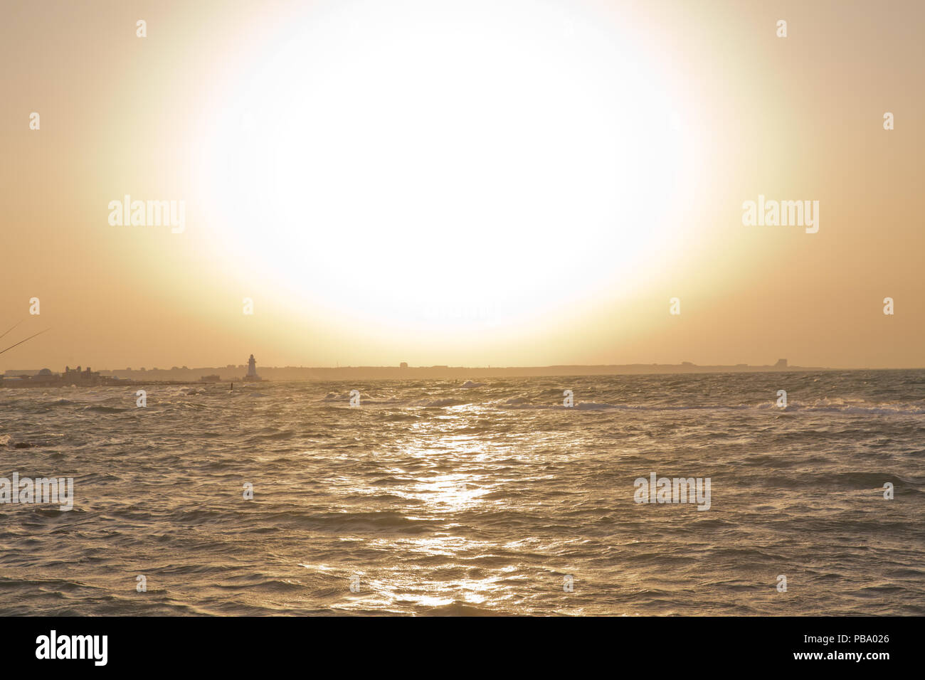 The fisherman fishes in the sea . Beautiful sunset at the beach ...