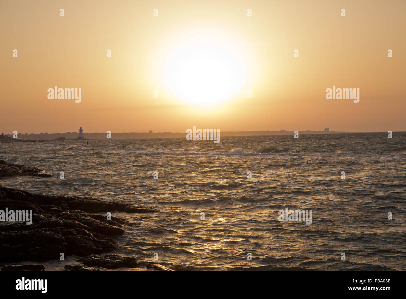 The fisherman fishes in the sea . Beautiful sunset at the beach ...