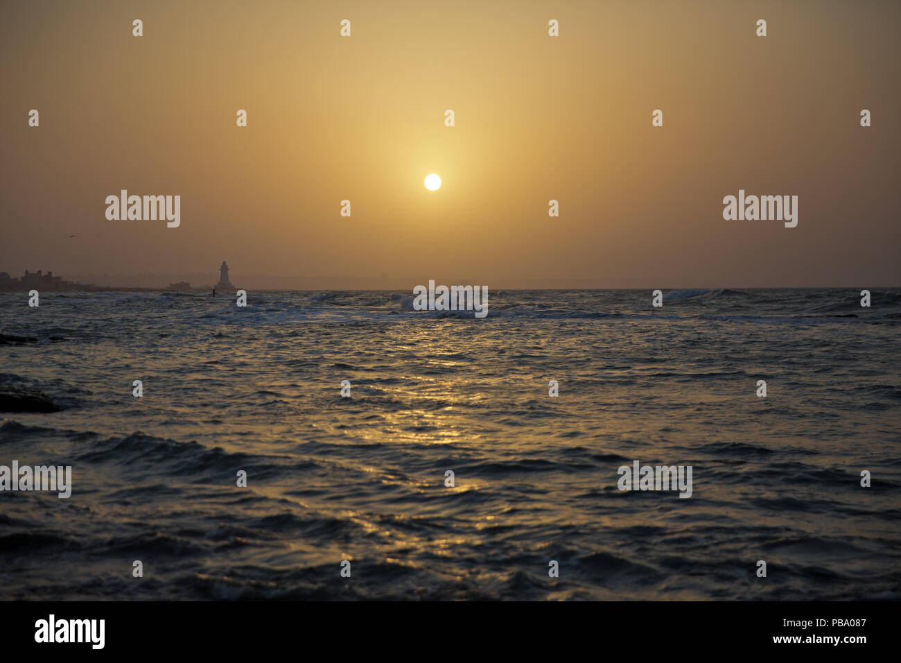 The fisherman fishes in the sea . Beautiful sunset at the beach ...